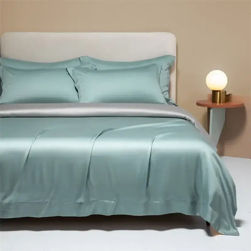 A smooth light teal satin duvet cover with matching pillowcases in a peach satin cooling cotton solid bedding set