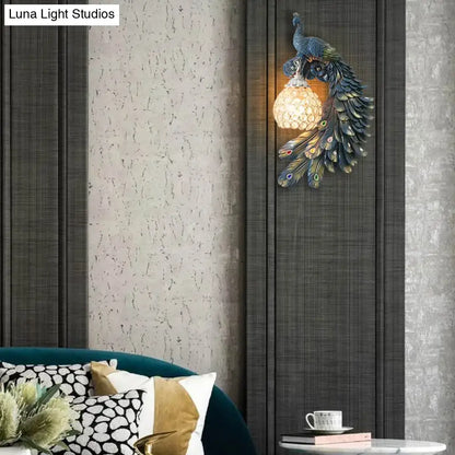Peacock blue and gold wall sconce with metallic finish, intricate feather details, and clear crystal dome shade for bedroom lighting