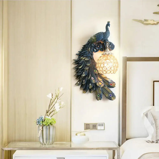 Peacock blue and gold wall sconce with iridescent feathers and clear crystal dome shade for bedroom lighting