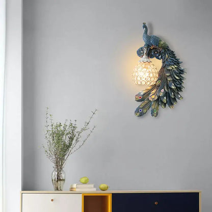 Peacock blue and gold wall sconce with iridescent feathers and clear crystal dome shade for bedroom lighting