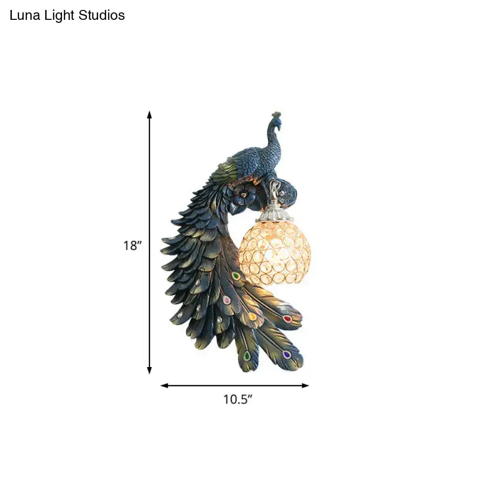 Peacock blue and gold wall sconce with detailed feather design and clear crystal dome shade for bedroom lighting