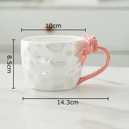 A white hammered porcelain mug with a pink bowknot handle from decorbites bowknot handle porcelain collection