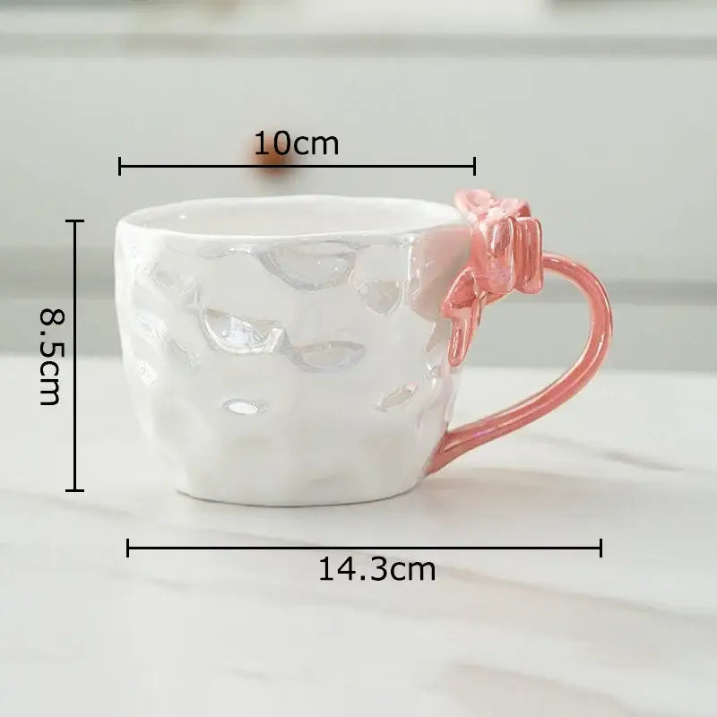 A white hammered porcelain mug with a pink bowknot handle from decorbites bowknot handle porcelain collection