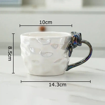 White ceramic mug with textured surface and iridescent red and silver decorbites bowknot handle porcelain design