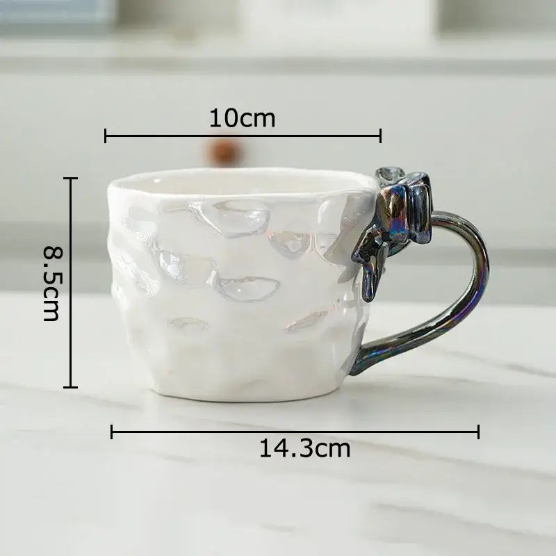 White ceramic mug with textured surface and iridescent red and silver decorbites bowknot handle porcelain design
