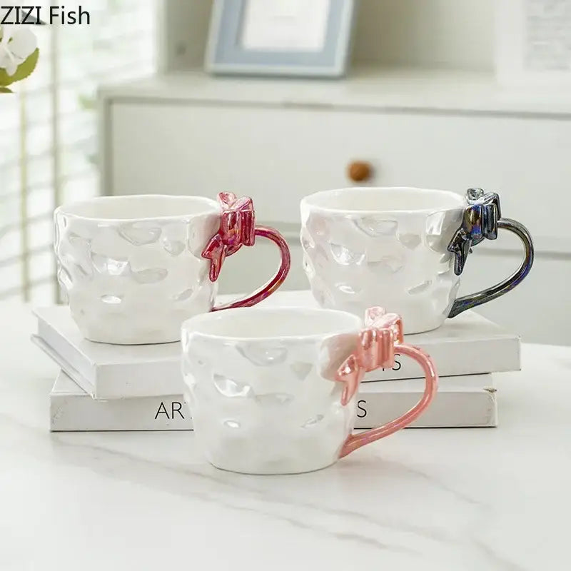 Three white ceramic mugs with pearl glazed bowknot handle porcelain in pink rose gold and dark blue decorbites bowknot handle