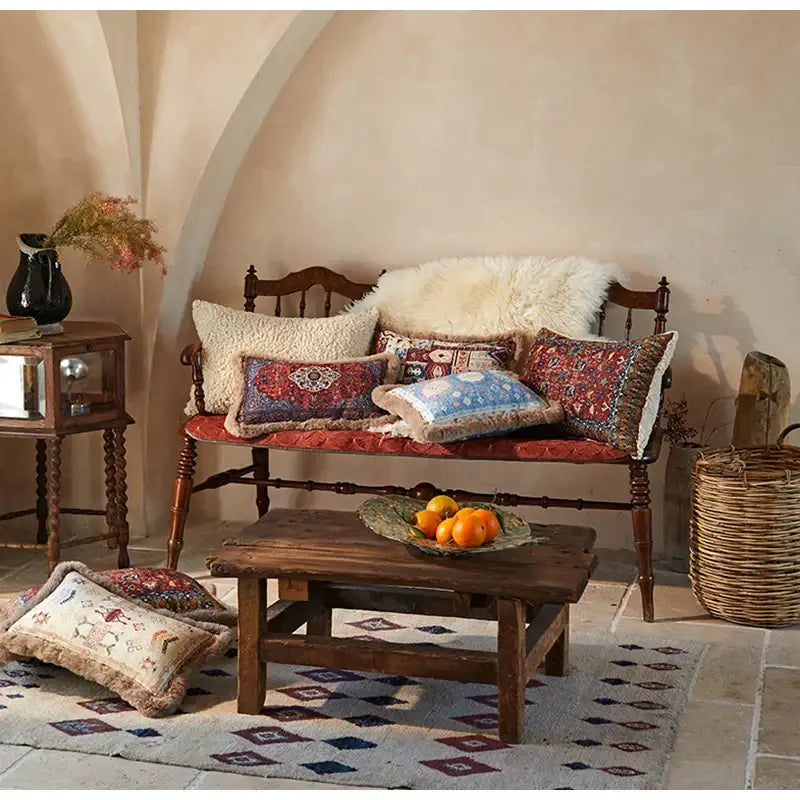 Wooden bench with ornate carvings upholstered in red fabric featuring decorbites bohemian chenille lumbar pillow cover
