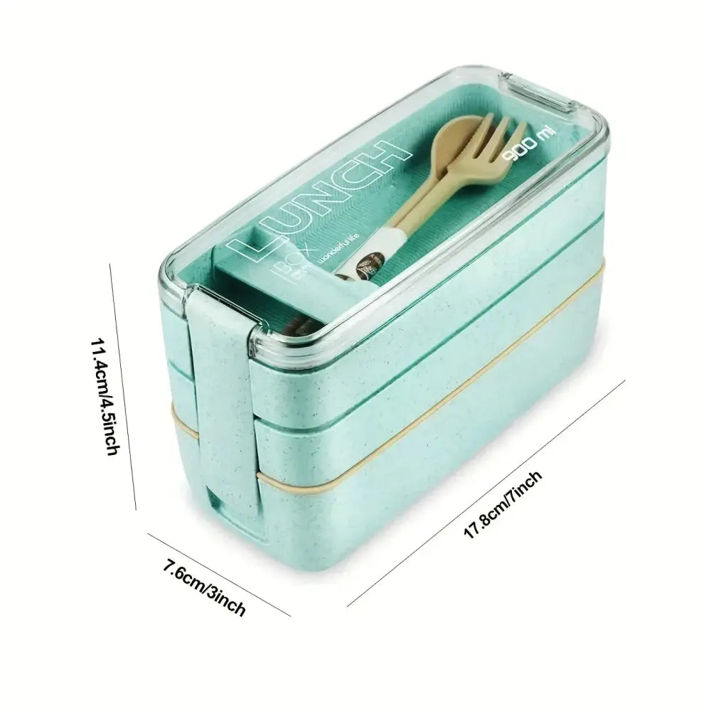 A light teal two-tiered kids bento box lunchbox with clear lid and beige utensils for kitchen food storage