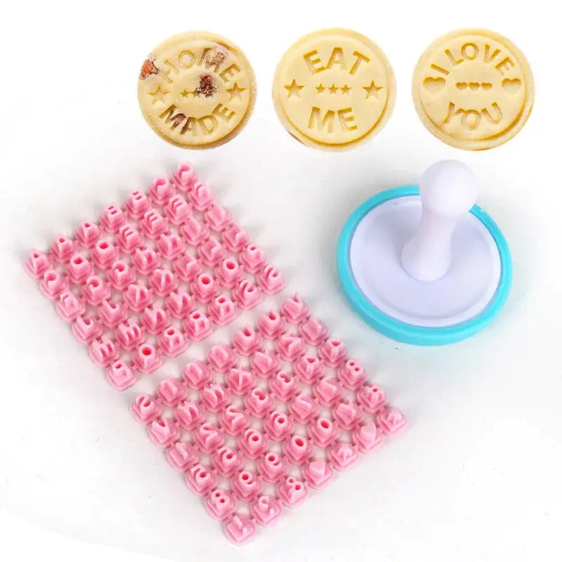 Set of three round decorbites cookie stamps with embossed phrases and a pink rose letter stamp with white blue handle