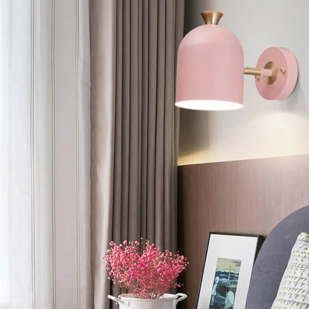 Pink dome-shaped wall light with brass-finished arm and mounting plate featuring a cup shade sconce lamp for dining rooms