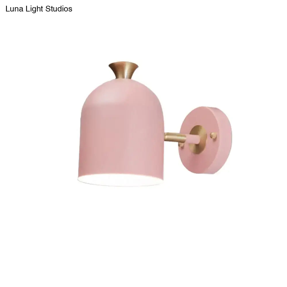 Pink matte-finished wall light sconce lamp with brass-colored arm and cup shade for dining room lighting