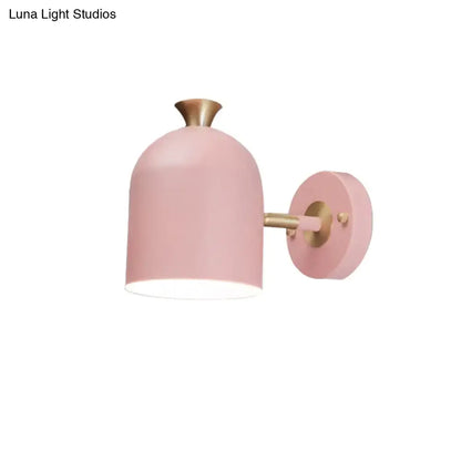 Pink matte-finished wall light sconce lamp with brass-colored arm and cup shade for dining room lighting