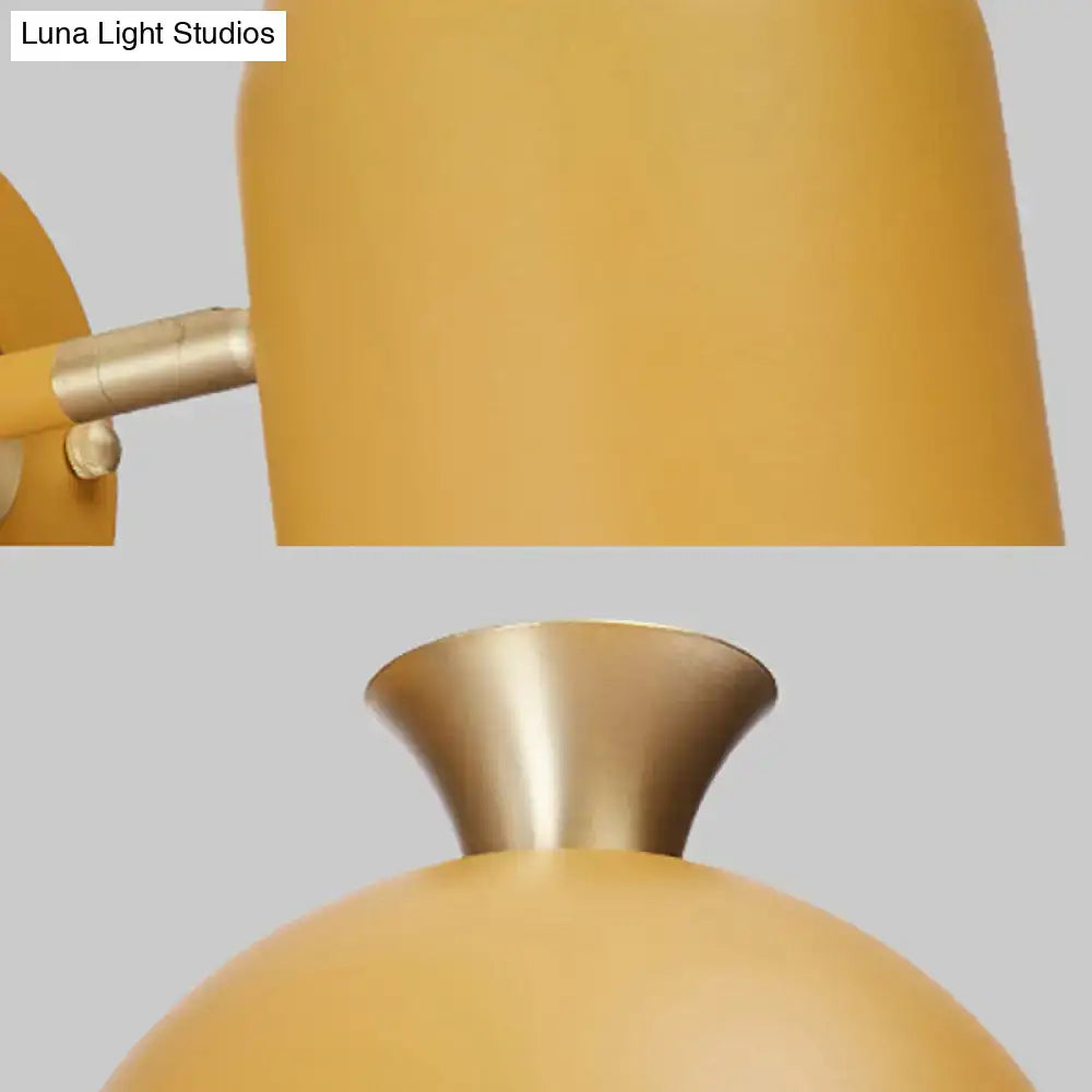 A sleek mustard-yellow cup shade wall light with matte finish and brushed brass sconce lamp for dining room use
