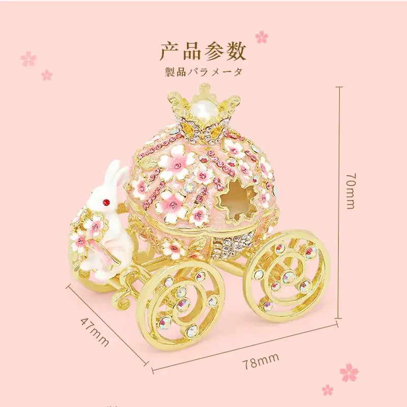 Delicate pink and gold princess carriage jewelry trinket box adorned with rhinestones, floral embellishments, and pearl crown