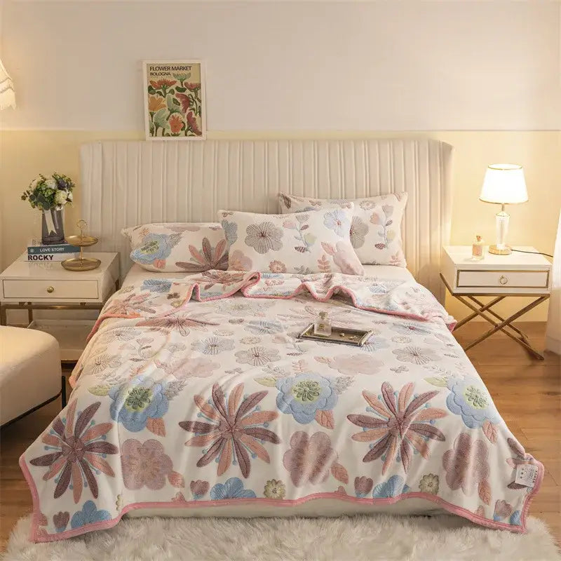 A soft fleece blanket with delicate pastel floral pattern and pink border featuring double sided plaid design