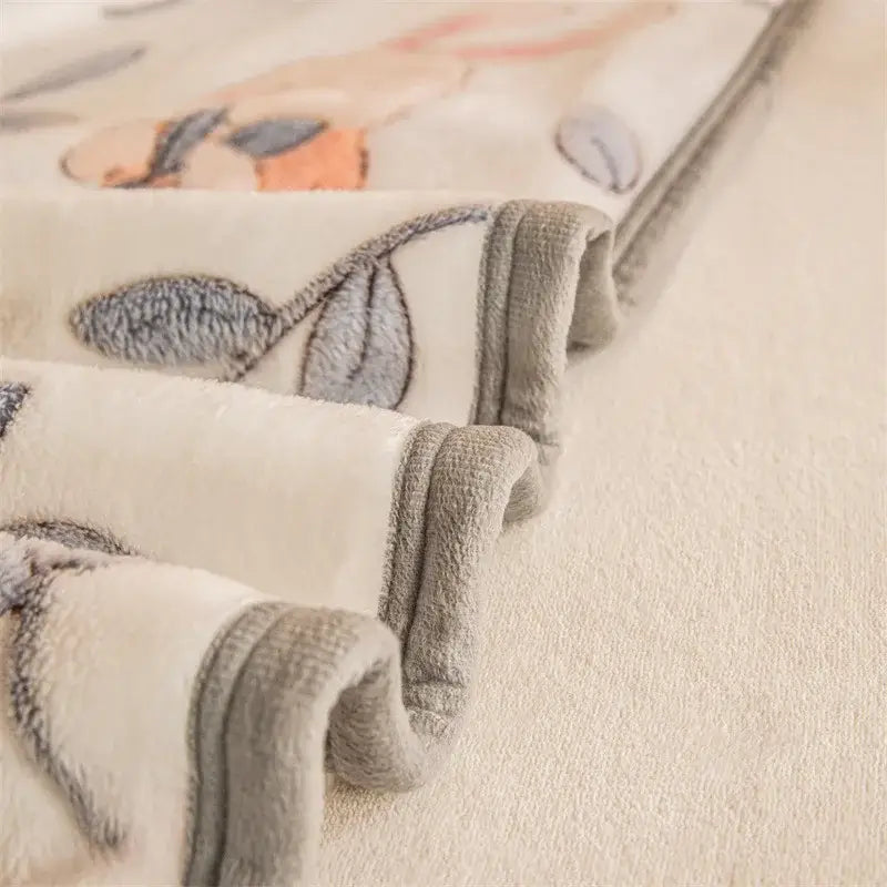 Cream-colored plush fleece blanket with soft textured fabric and embroidered gray leaves from double sided plaid collection