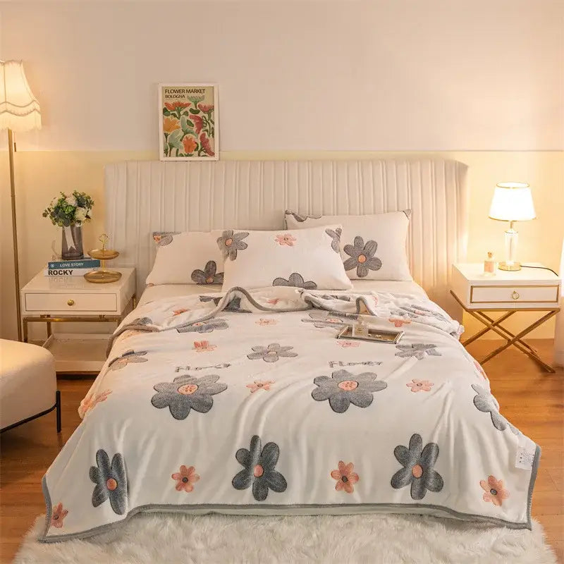 Fluffy white fleece blanket with gray and pink floral pattern features soft plush material in double sided plaid design