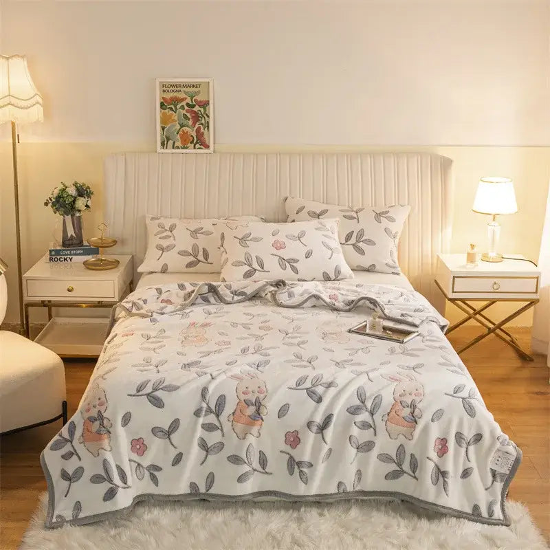 White fleece blanket with double sided plaid featuring pink bunnies and gray leaves in soft plush fabric