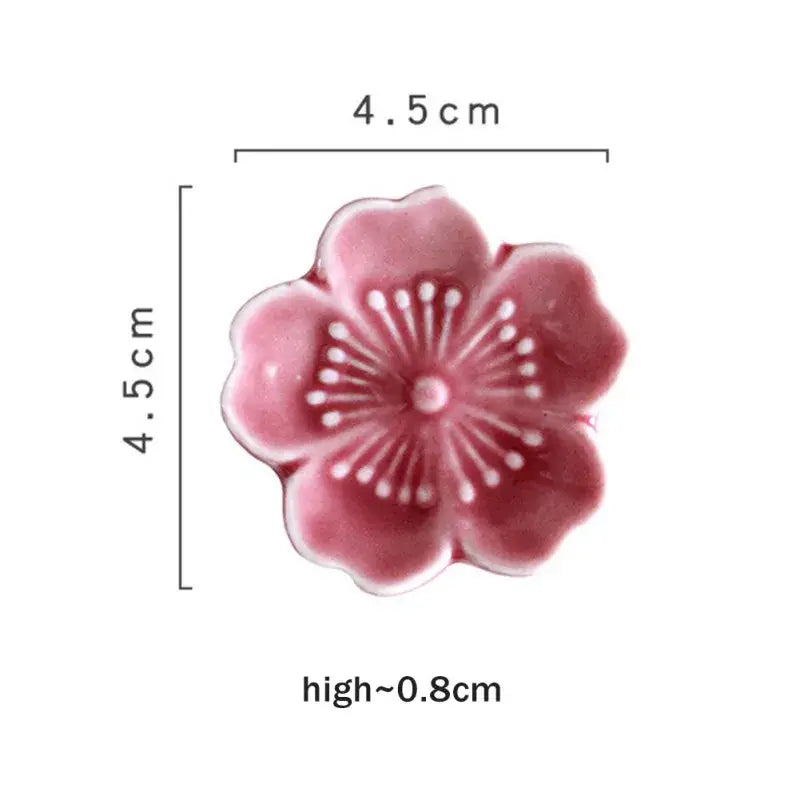 Pink and green decorbites ceramic sakura chopstick rest shaped like a delicate pink ceramic cherry blossom dish with white stamens