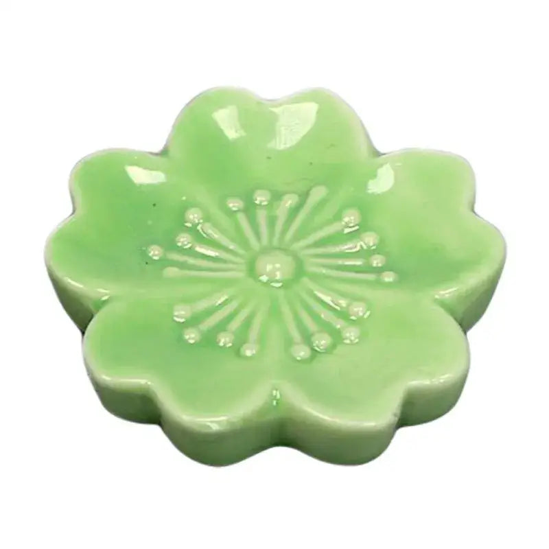 A delicate light green ceramic sakura chopstick rest with embossed floral pattern for dining room decorbites ceramic sakura