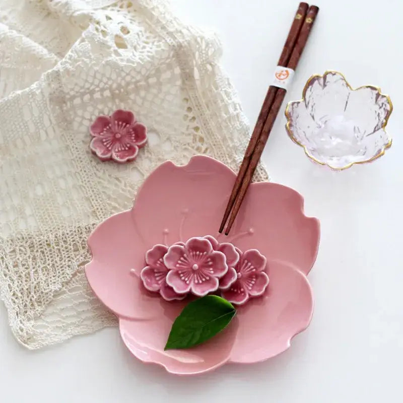Pink and green ceramic sakura chopstick rest with a cherry blossom plate and floral decorations for dining room decor