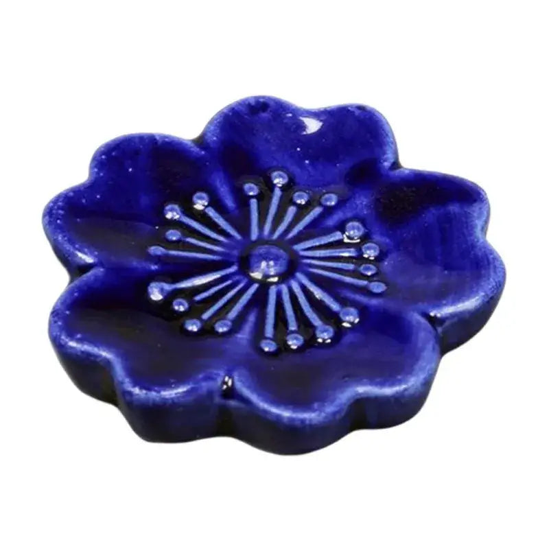 Deep blue ceramic sakura chopstick rest shaped like a flower with embossed petals and starburst decorbites ceramic sakura design
