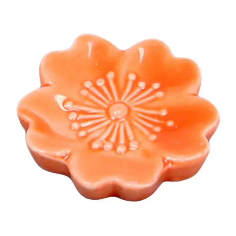 Glossy orange decorbites ceramic sakura chopstick rest shaped like a cherry blossom with embossed petal details