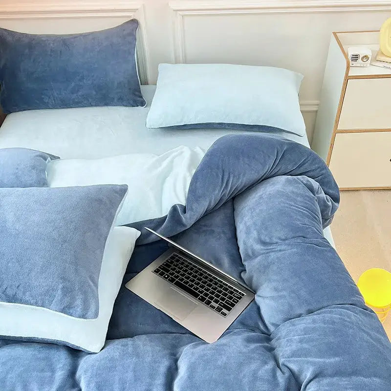 Soft blue milk velvet bedding set with duvet cover and pillows featuring a silver laptop in a winter bedroom