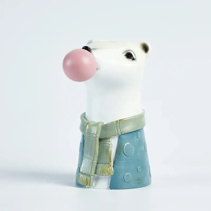 White ceramic polar bear figurine wearing green scarf and blue polka-dot pants blowing pink bubble gum flower vase decorbites bubble gum