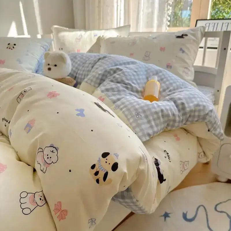 Cream-colored cartoon printed cotton quilt cover with playful dog and bow patterns paired with blue gingham quilt