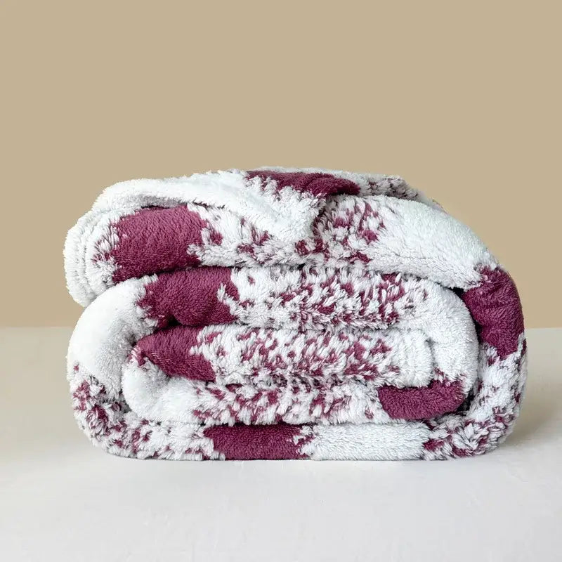 A decorbites cationic jacquard blanket with maroon and white speckled pattern and soft white fleece side