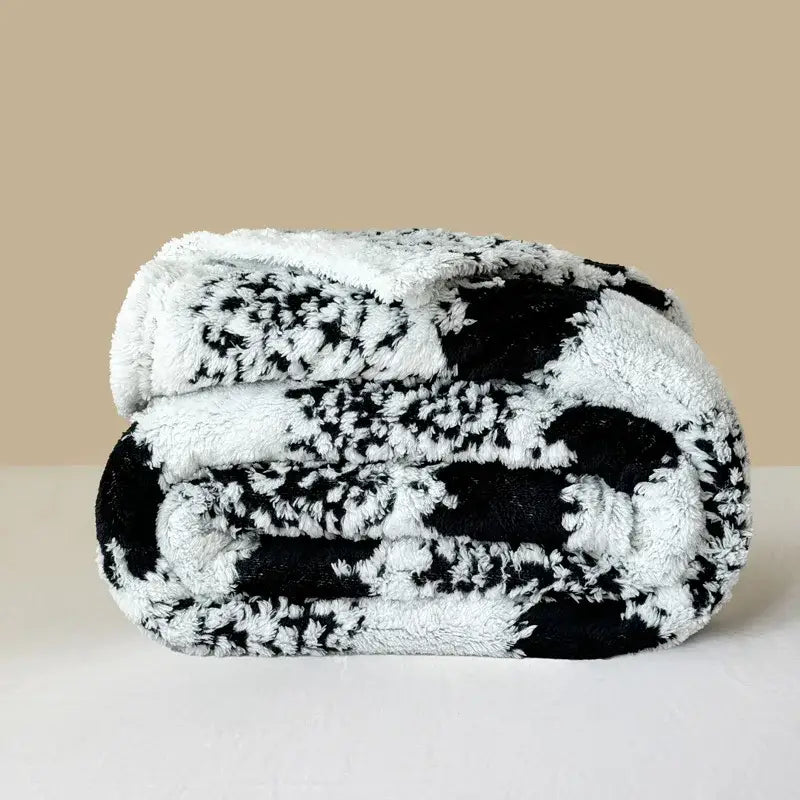 A plush black and white decorbites cationic jacquard blanket with soft fuzzy texture for cozy bedroom decor