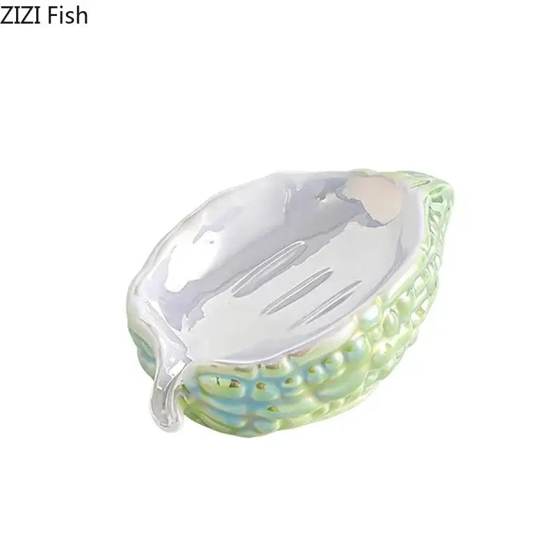 Glossy pink and yellow bitter gourd ceramic soap dish shaped like a seashell with pearlescent sheen and drainage rack