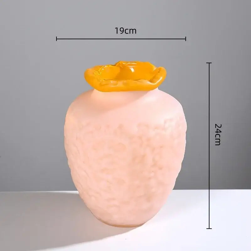 A blush pink frosted glass vase with a textured surface and vibrant yellow flower rim for decorbites colorful frosted decor