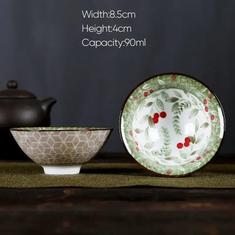 A white porcelain hand-painted bowl with a green rim red berry design and geometric pattern from decorbites blue dining set