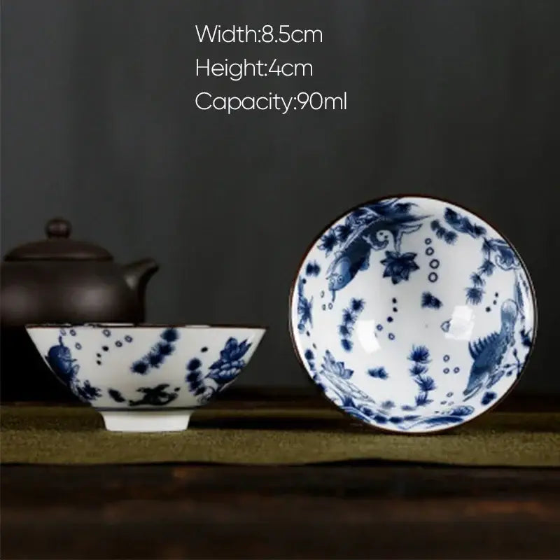 A delicate white porcelain hand-painted tea bowl with blue underglaze floral and fish motifs from decorbites blue collection