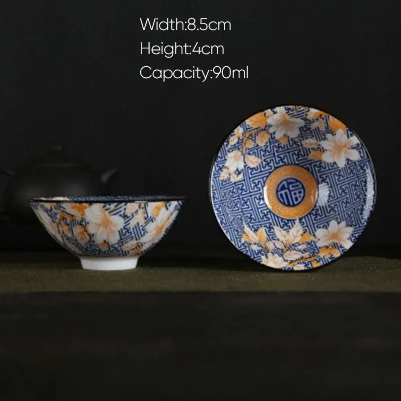A decorbites blue and white porcelain hand-painted ceramic bowl with floral pattern and orange center on matching saucer