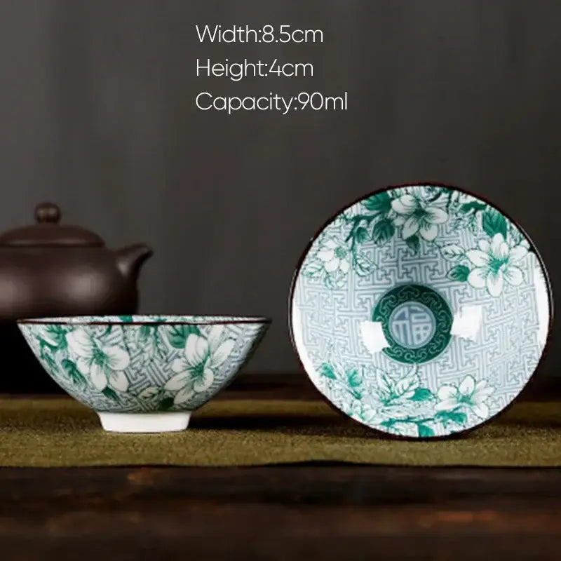 A delicate white porcelain hand-painted tea bowl with green floral pattern and geometric rim design for decorbites blue set