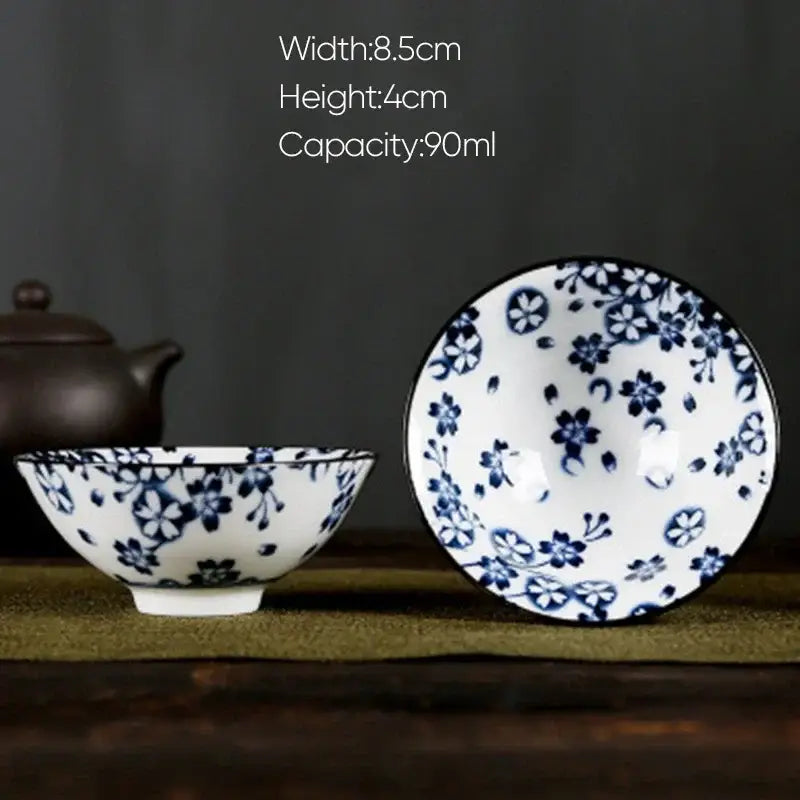A delicate white porcelain hand-painted bowl with intricate blue floral decorbites blue patterns and matching rim