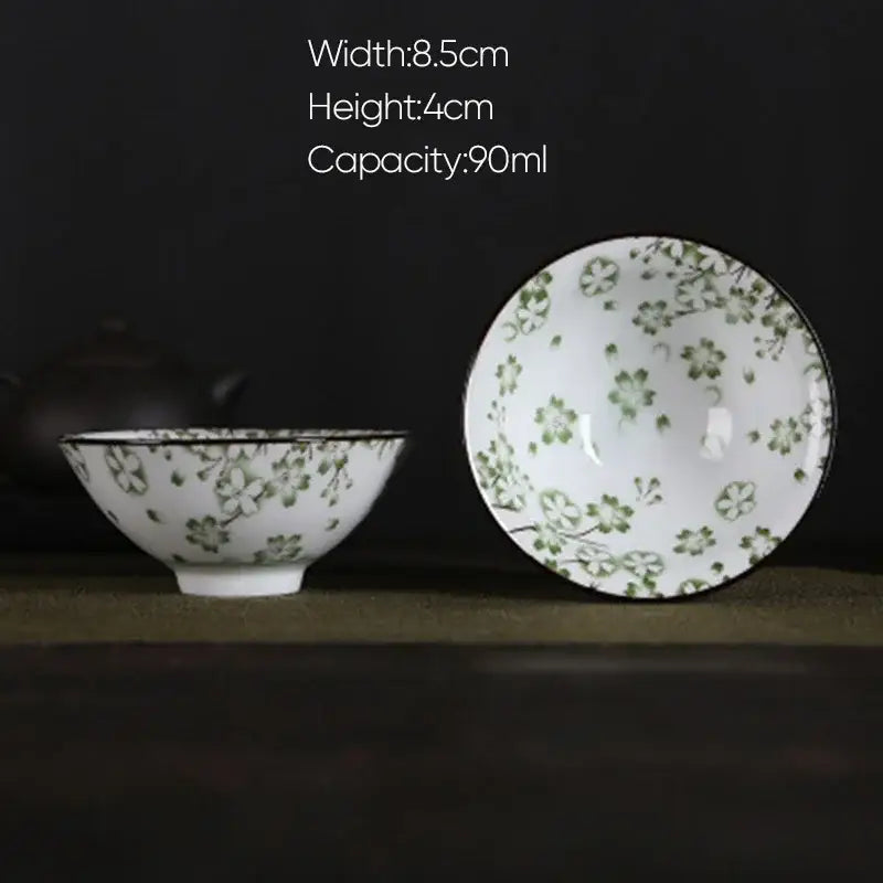 White porcelain hand-painted bowl with delicate green floral patterns and black rim from pink and black floral set decorbites blue