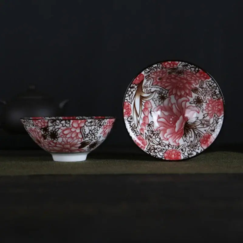 A pair of white porcelain hand-painted bowls with intricate pink and black floral patterns and glossy finish