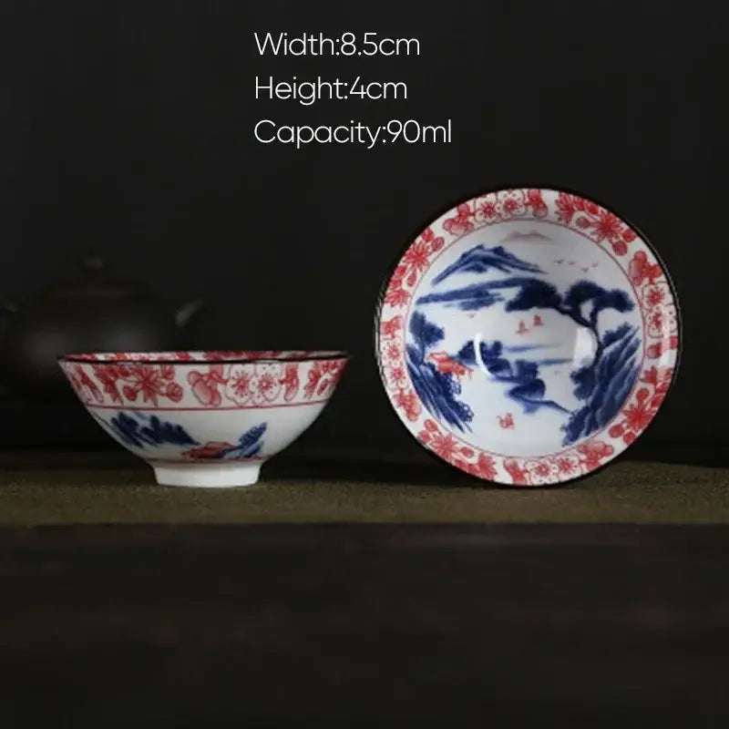 A traditional white porcelain hand-painted tea bowl with blue and red floral and landscape decorbites blue patterns