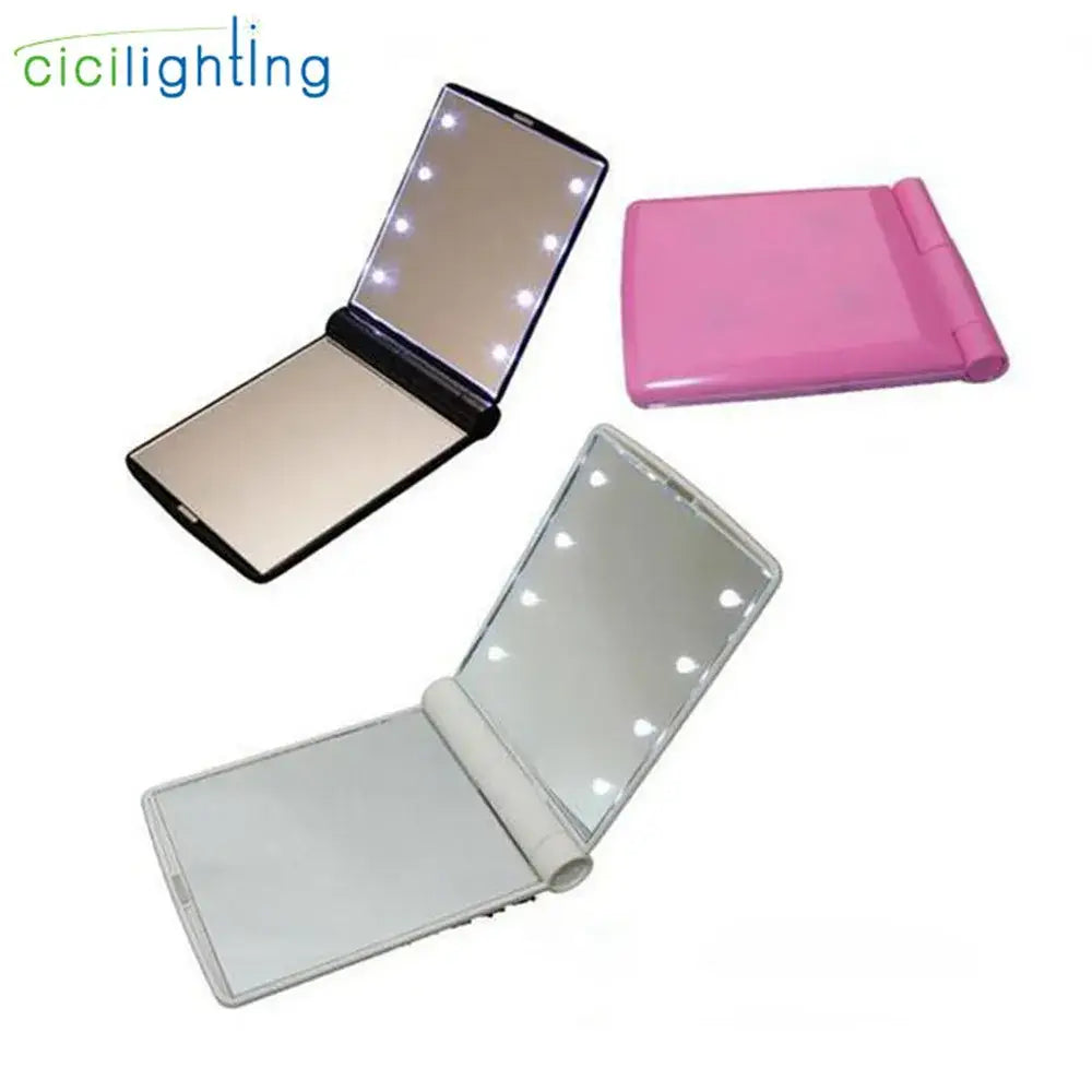 Pink and black led vanity mirror compact with foldable illuminated panels for bedroom makeup use