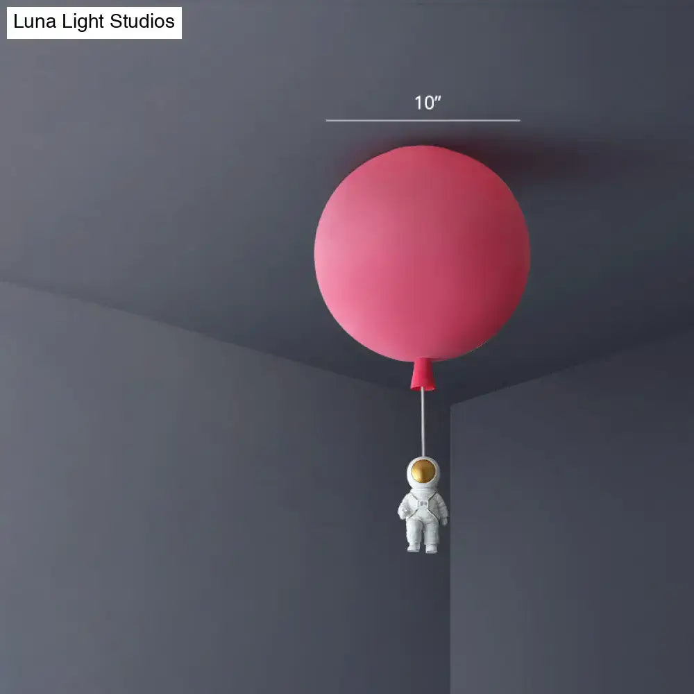 Pink and blue astronaut ceiling lamp featuring a pink balloon-shaped light with a white astronaut figurine pendant