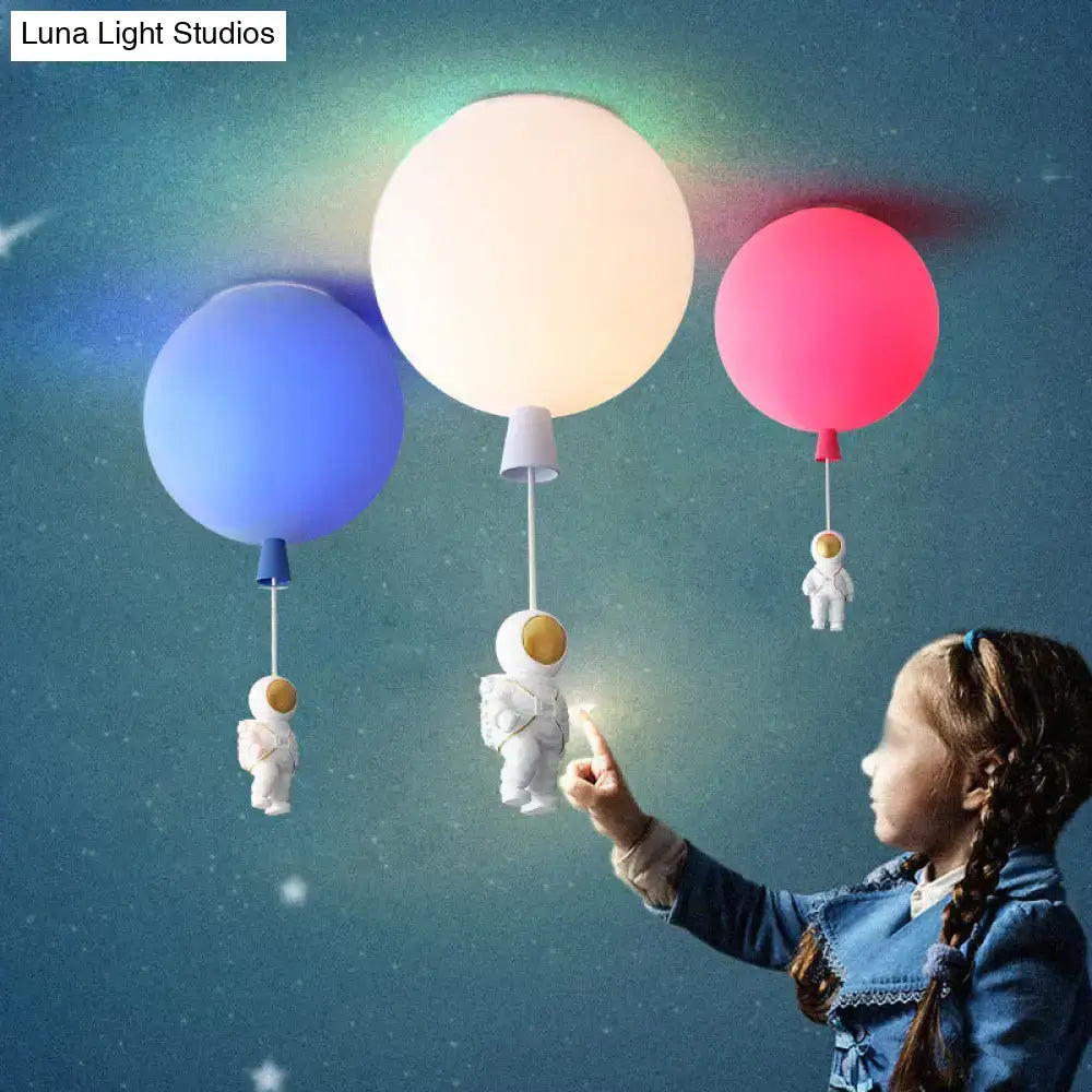 Three colorful pink and blue balloon-shaped led astronaut ceiling lamps with hanging astronaut figurines for bedroom use