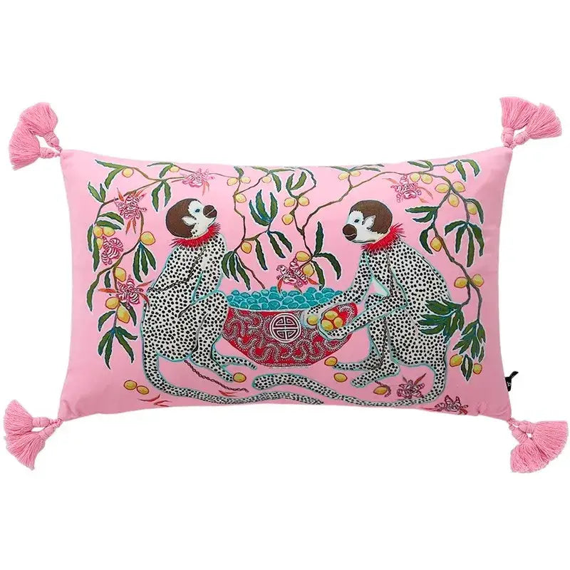 Pink rectangular cushion with embroidered spotted monkeys and tassels complements blue lion dog lumbar pillow decor