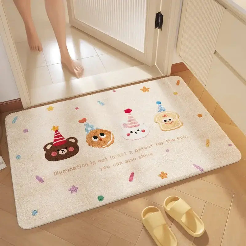 Cream-colored plush bathroom mat with soft absorbent fabric and decorbites cartoon print featuring festive party hats