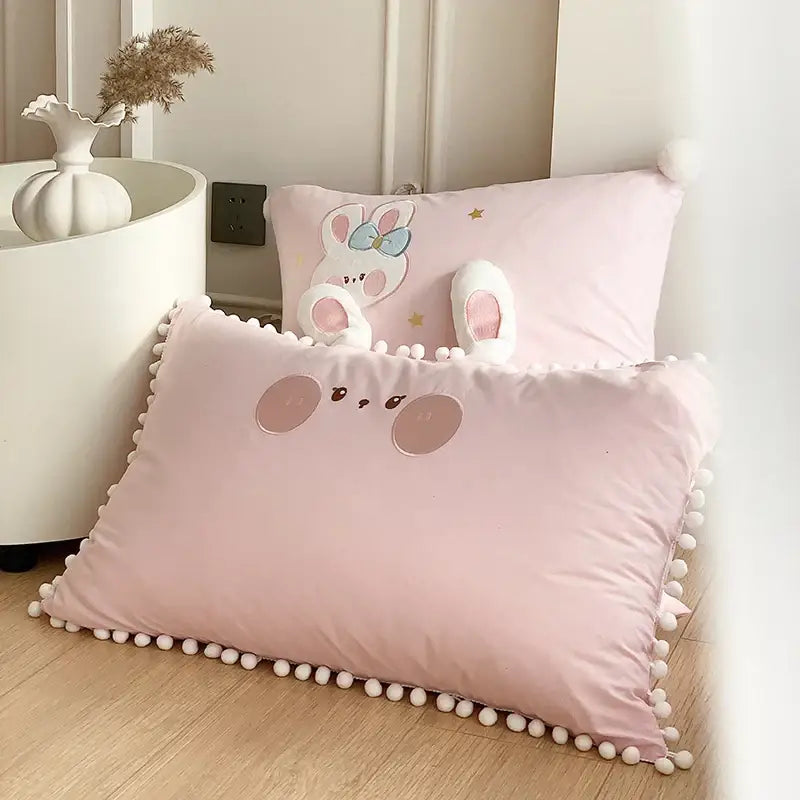 Pink cotton pillow with pom-pom trim and embroidered bunny face from decorbites cartoon rabbit moon bedding set
