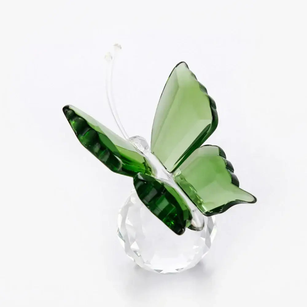 A translucent green decorbites crystal butterfly figurine with faceted wings on a clear crystal base for bedroom decor