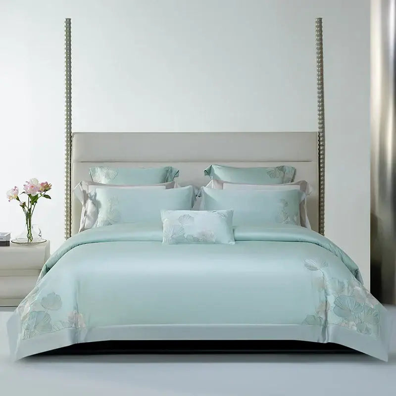 A soft mint green satin bedding set with delicate decorbites cotton flowers embroidery and matching pillow ensemble